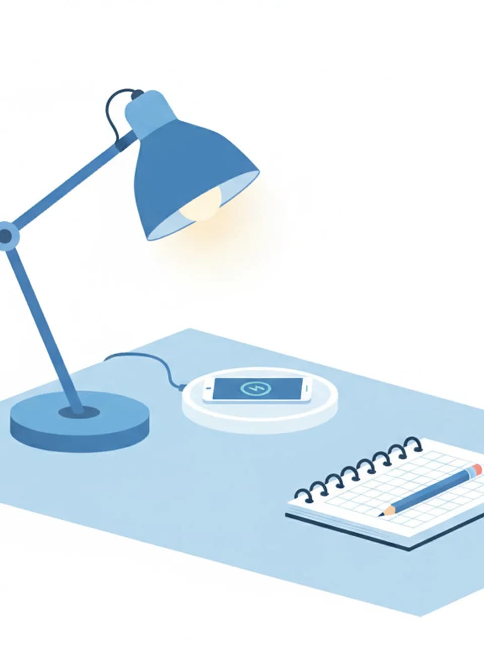 Scrivania ordinata con lampada accesa, smartphone in carica e quaderno aperto